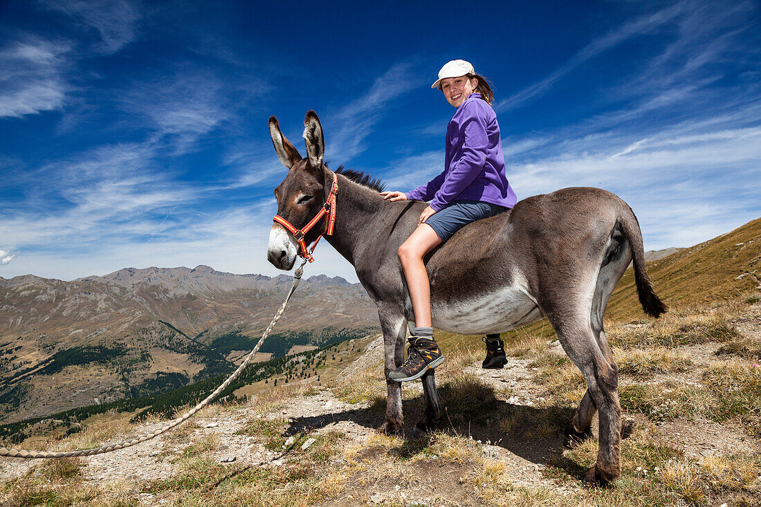 Mädchen auf Esel, Eselswanderung im Queyras, Alpen, Frankreich, Europa