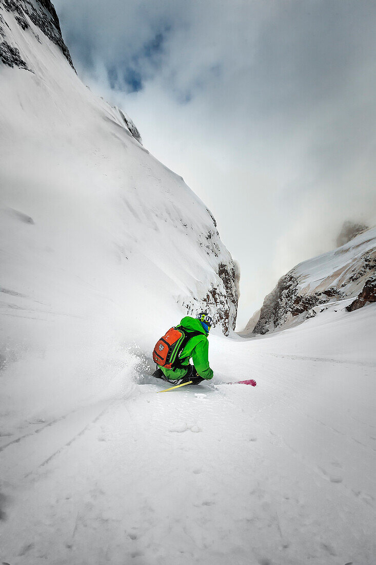 A man enters a steep couloir during a foggy afternoon in San Martino si Castrozza in the Dolomites