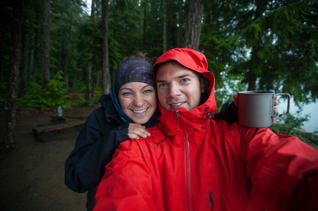 A couple take a selfie  on a wet day while camping in Bowron Lake Provincial Park.