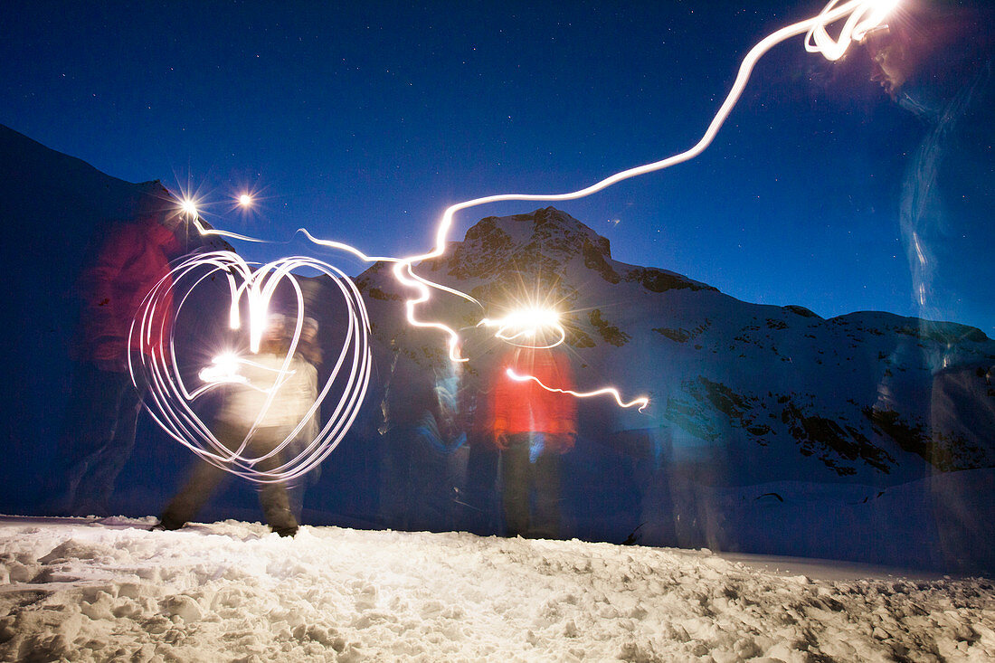 Several friends have fun painting with light during a camping trip below Joffre Peak in British Columbia, Canada.