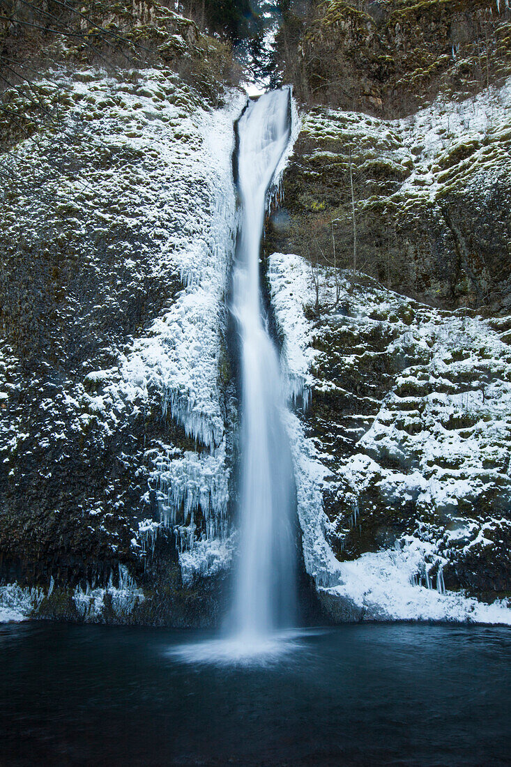Icy waters of Horestail Creek flow over Horestail Falls in the winter, Columbia River Gorge National Scenic Area, Oregon.