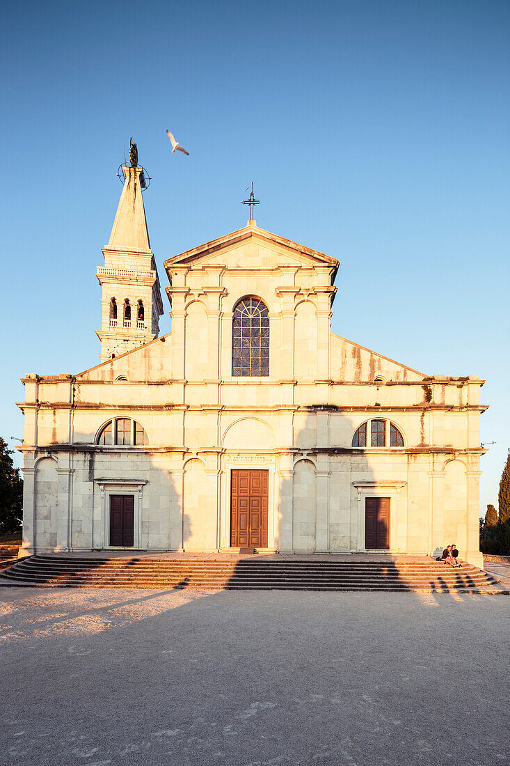 Ein Pärchen genießt die letzten Sonnenstrahlen vor der Kirche Sveta Eufemija, Rovinj, Istrien, Kroatien