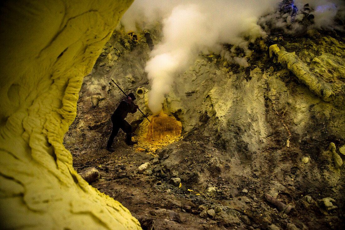 Mienenarbeiter in der Teufelsmine des Vulkan Ijen beim Schwefelabbau mit der Brechstange - Indonesien, Java