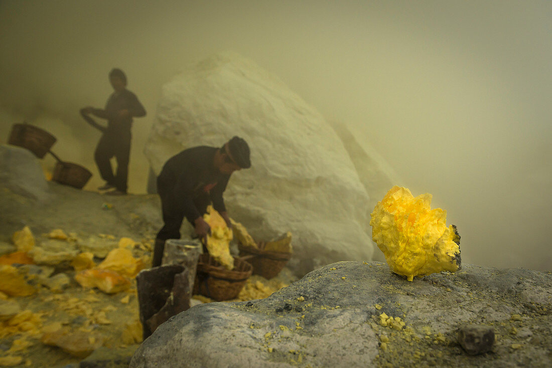 Mienenarbeiter in der Teufelsmine des Vulkan Ijen beim Beladen der Transportkörbe mit Schwefel - Indonesien, Java