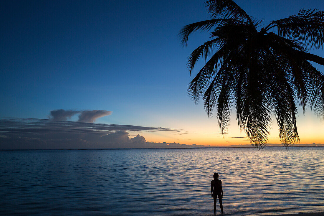 Woman at sunrise at Meeru Island Resort, Meerufenfushi, North-Male-Atoll, Maldives