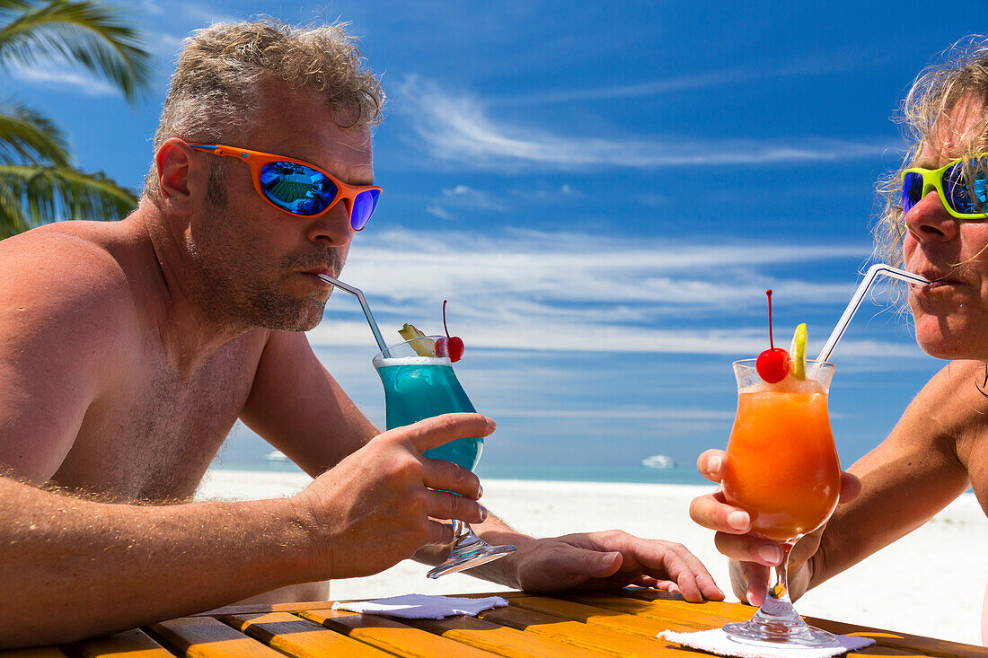 Ein Mann und eine Frau trinken Cocktails, Strandbar, Meeru Island Resort, Meerufenfushi, Nord-Male-Atoll, Malediven