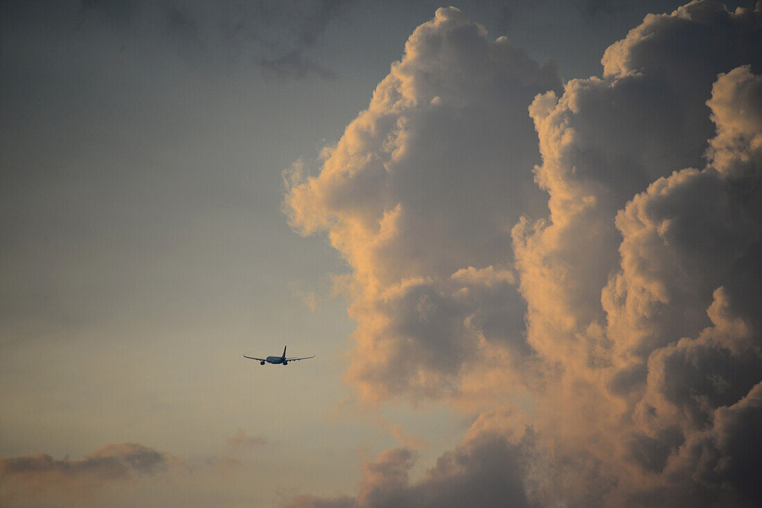 startendes Flugzeug mit Wolken, Asien