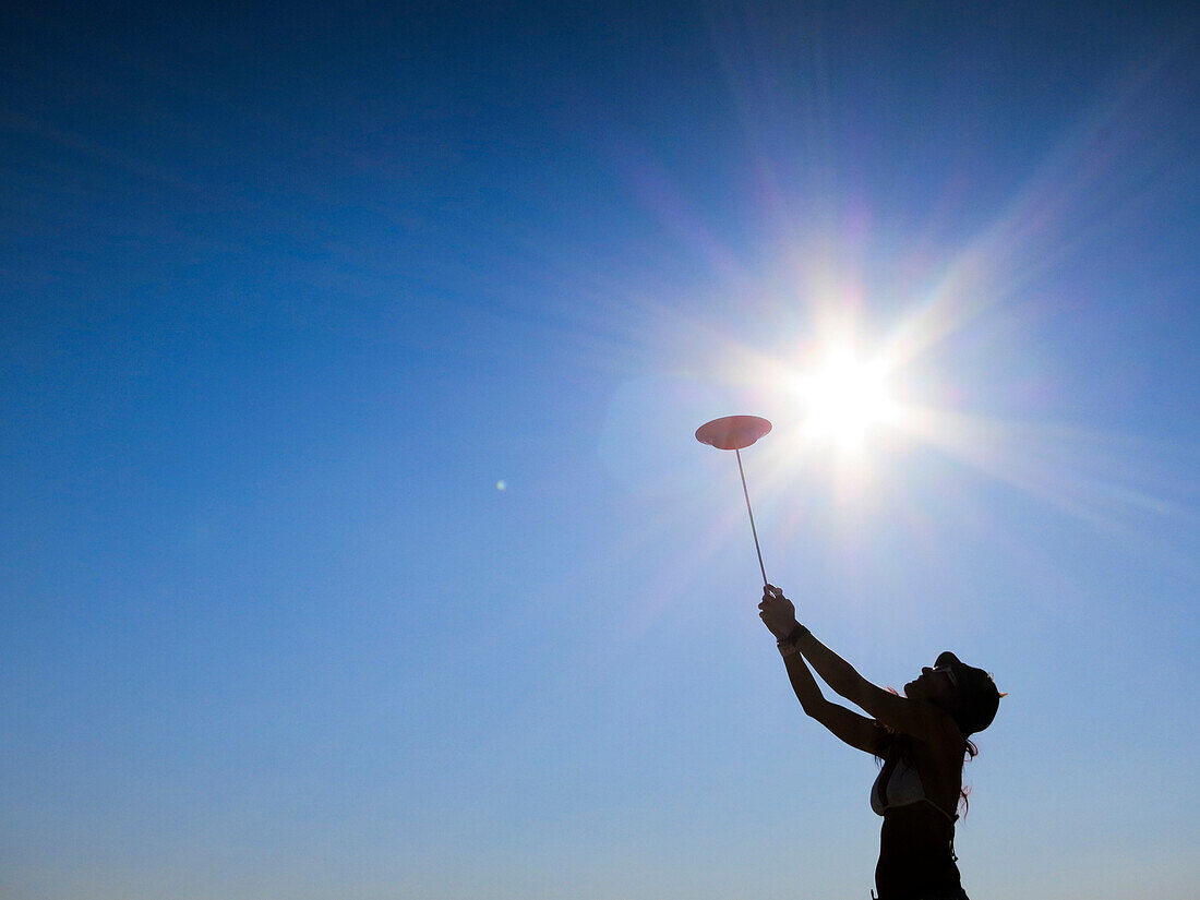 Silhouette of woman spinning plate