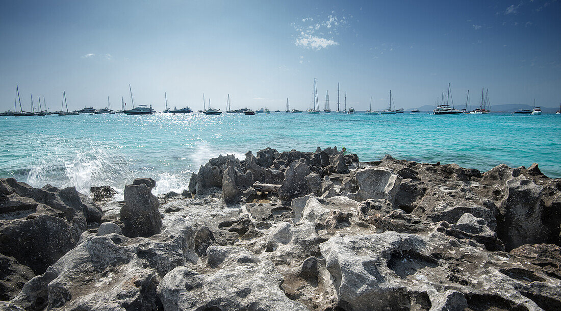 Jagged rocks with sailboats idling in the azure waters of Formentera, Balearic Islands, Spain, Mediterranean, Europe