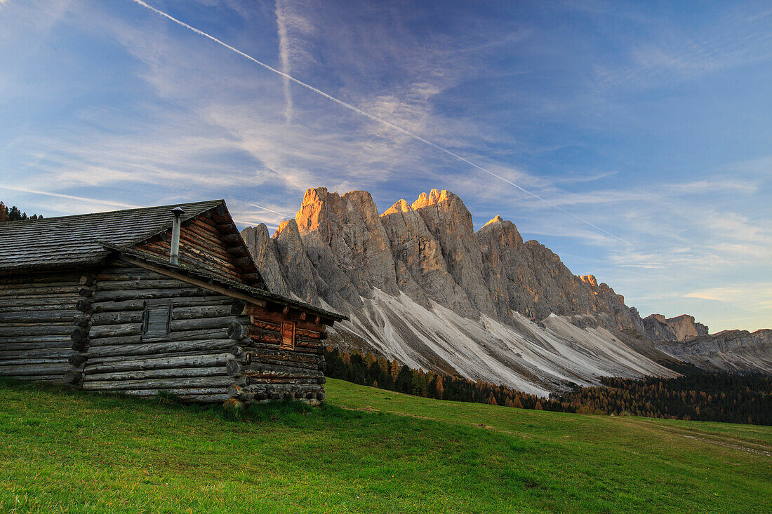 The early morning light illuminates Malga Zannes and the Odle in background, Funes Valley, South Tyrol, Dolomites, Italy, Europe