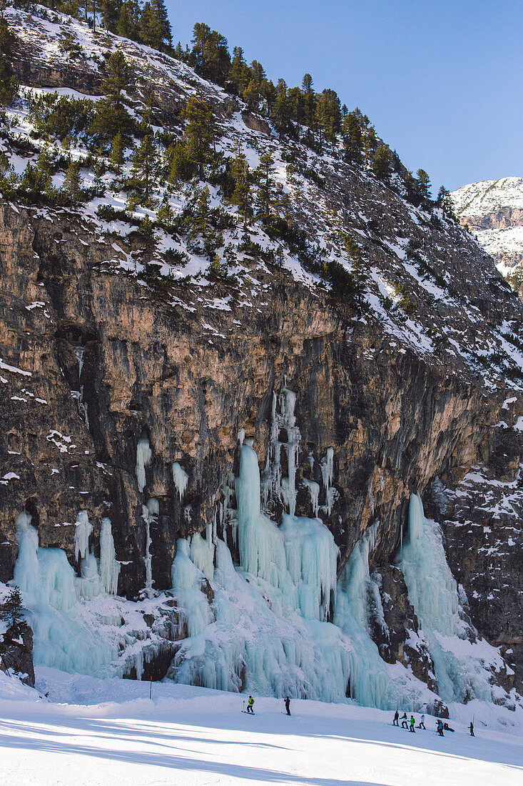 Skiers underneath the frozen waterfall, Hidden Valley ski area, Lagazuoi, Armentarola 101, Ski piste, Dolomites, UNESCO World Heritage Site, South Tyrol, Italy, Europe