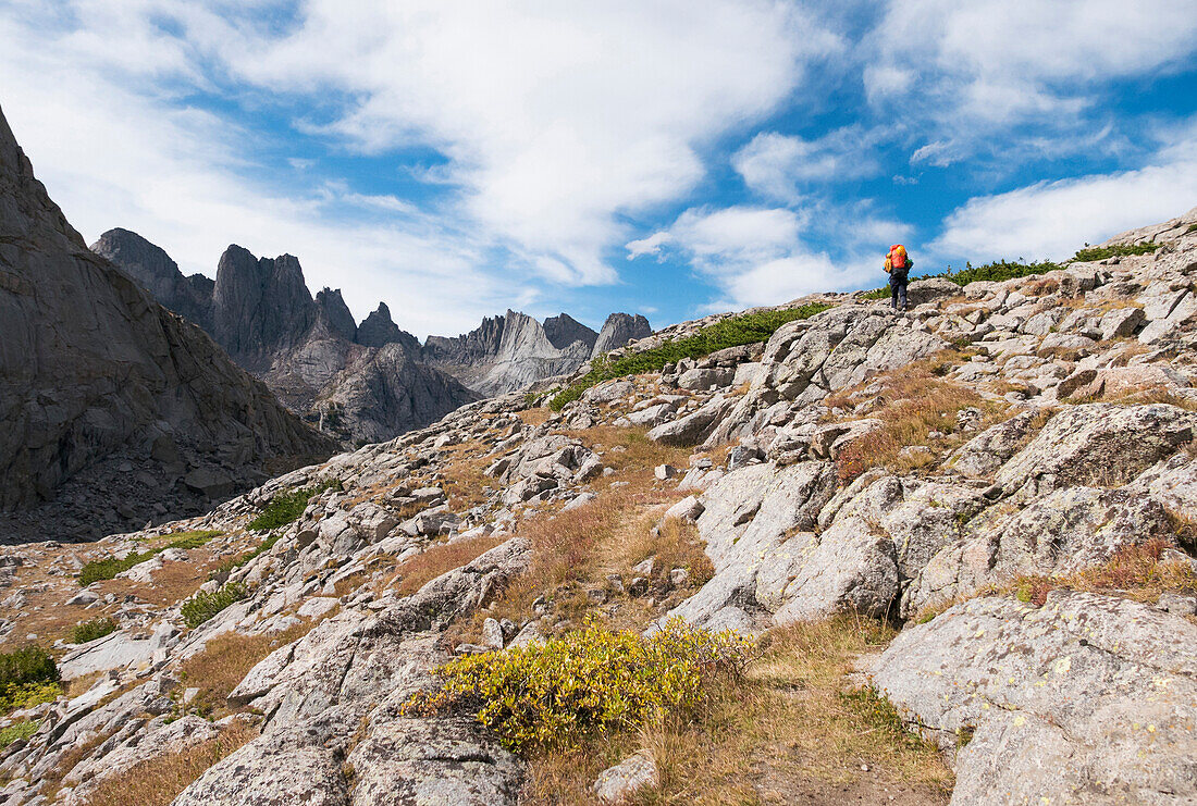 Caucasian hiker walking on rocky hillside