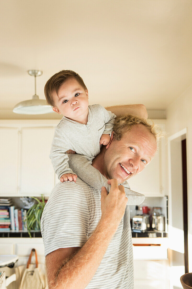 Father carrying baby son on shoulders