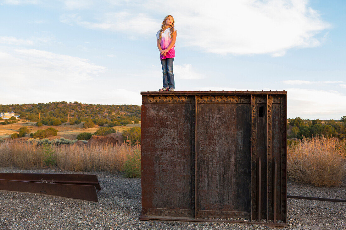 Caucasian girl standing on rusting structure outdoors