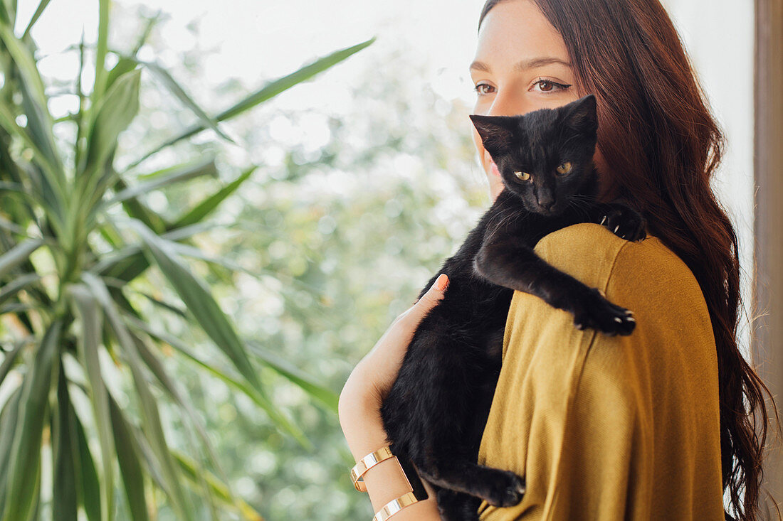 Caucasian woman holding kitten