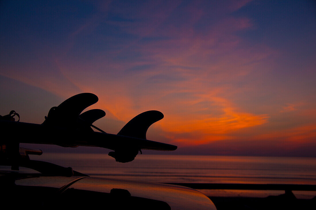 Silhouette of Surfboard on Car at Sunset