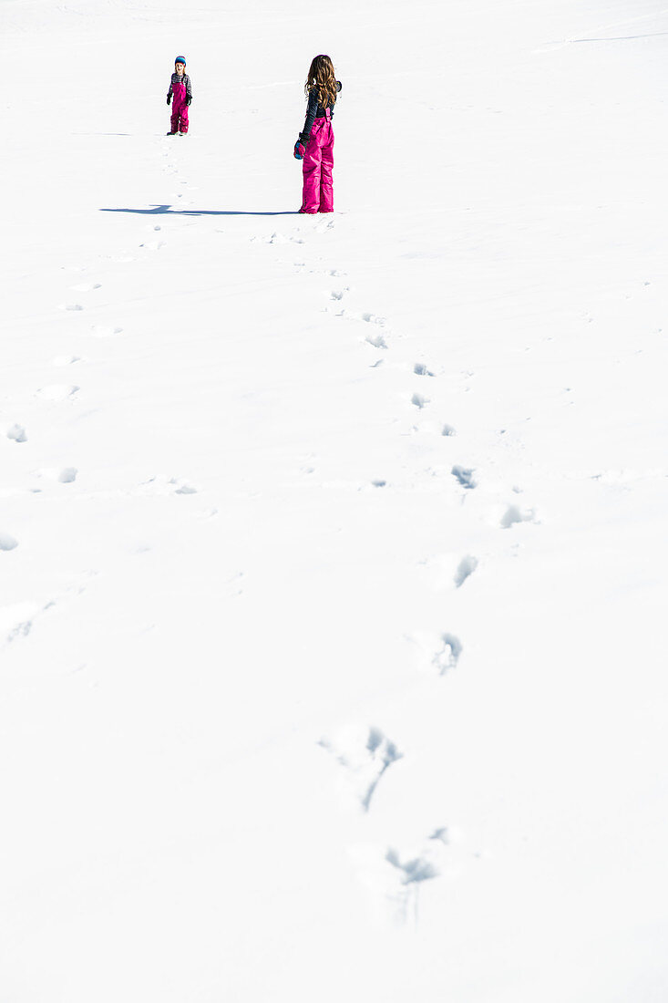 Mädchen und Junge stapfen durch den Schnee im Winter, Pfronten, Allgäu, Bayern, Deutschland
