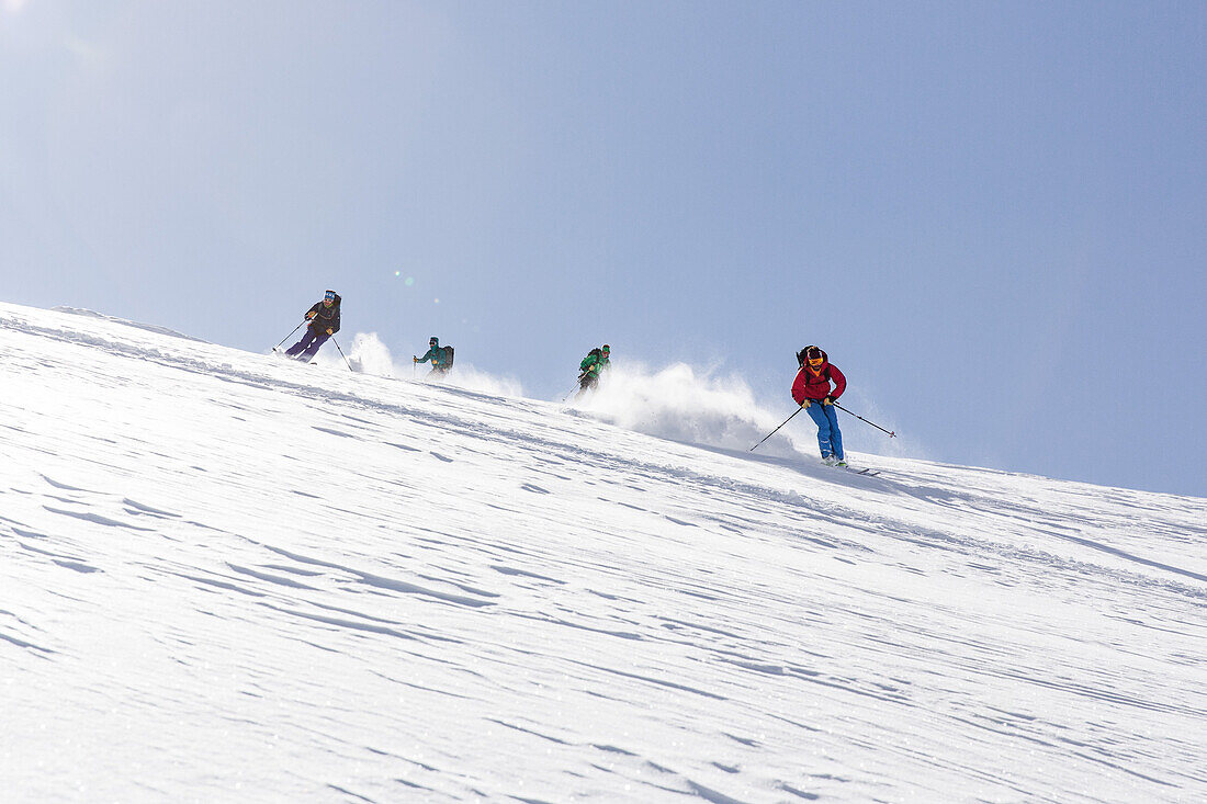 Group of people alpine skiing, powder skiing, avalanche assessment on a ski tour, risk management with groups, Vorderes Galmihorn, Obergoms, Berner Oberland, Switzerland