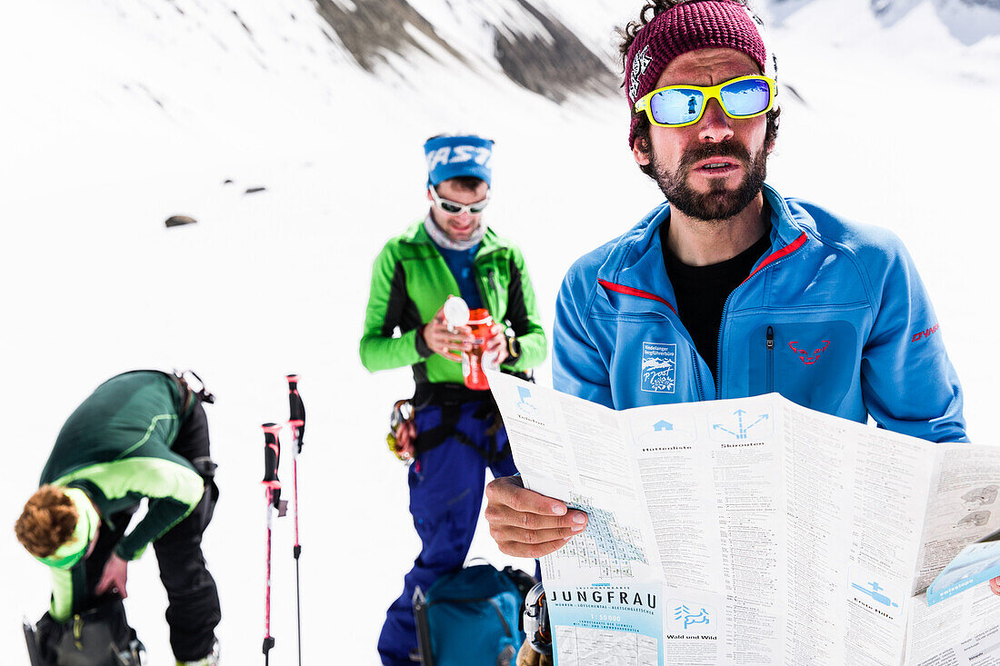 mountain guide checking the map for orientation, risk management with groups, Fiescher Glacier, Berner Oberland, Switzerland