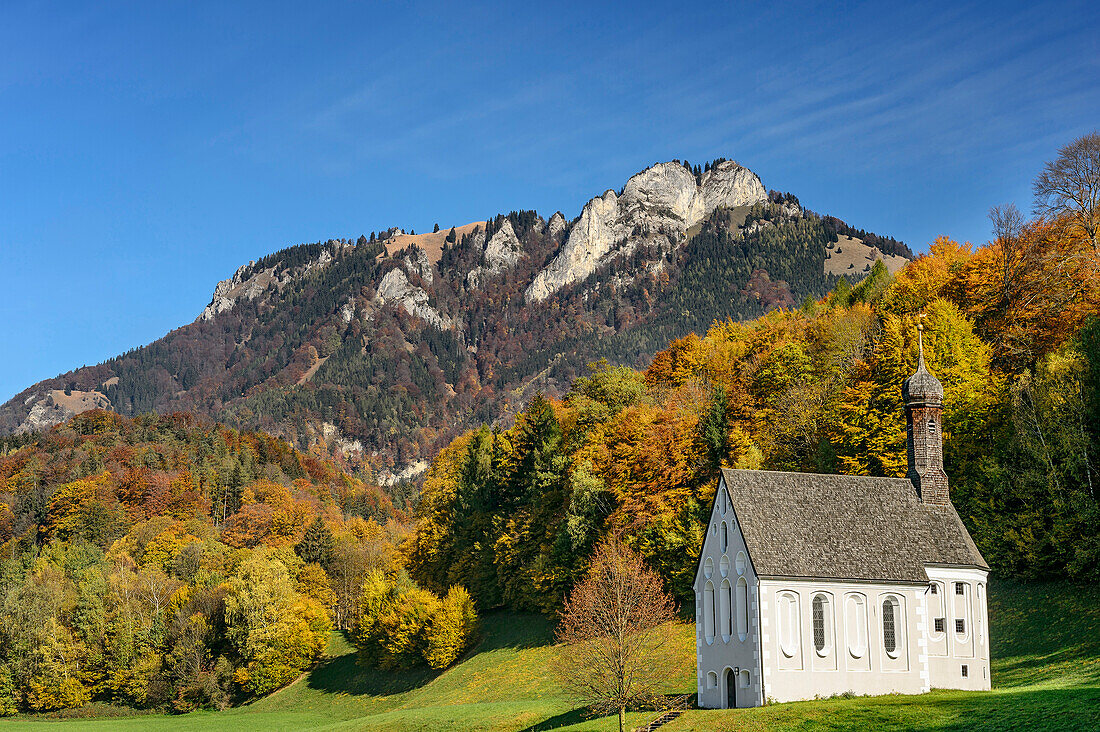 Chapel Zum Heiligen Kreuz with forest in autumn colours and Heuberg, valley of Inn, Chiemgau, Chiemgau Alps, Upper Bavaria, Bavaria, Germany