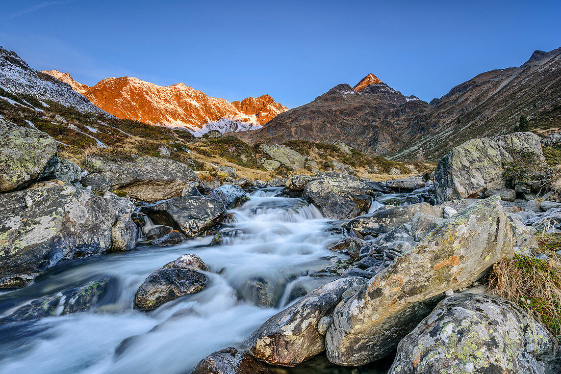 Mountain river with Debantgrat, Ralfkopf and Gloedis in alpenglow in background, valley of Debanttal, Schober Range, High Tauern, High Tauern National Park, East Tyrol, Tyrol, Austria