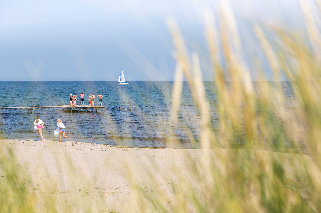 Leute am Bootssteg und im Meer, Strand im Norden der Insel, Segelboot, Strandurlaub, dänische Ostseeinsel, Ostsee, Insel Bornholm, Sandvig, Dänemark, Europa