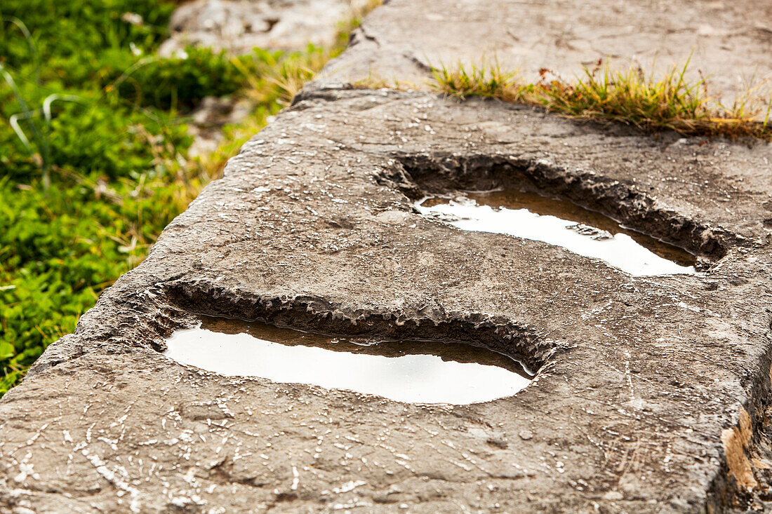 Footprints in a stone wall filled with water, Delphi, Greece