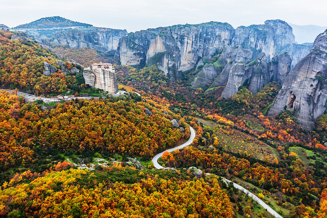 Monastery perched on a cliff with autumn coloured foliage, Meteora, Greece