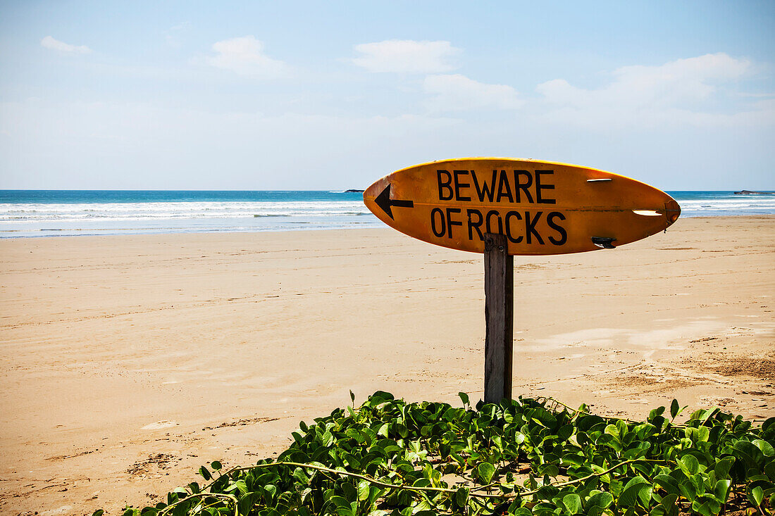 A warning sign on a surfboard in Playa Hermosa, Nicaragua