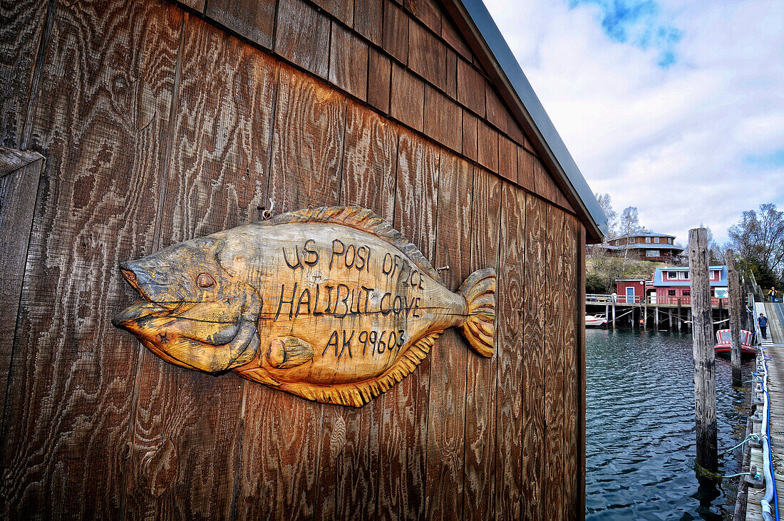 A wooden sign in the shape of a halibut announces the U.S. Post Office in Halibut Cove, Southcentral Alaska
