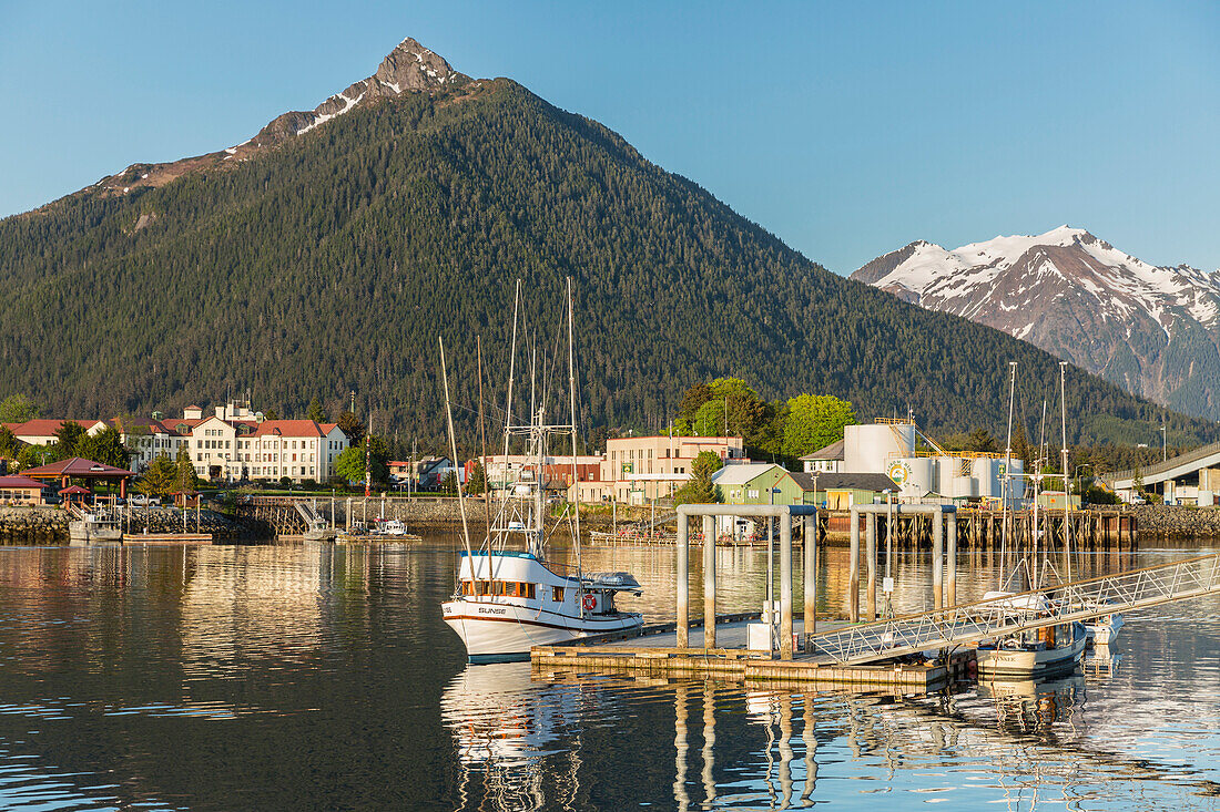Fishing boat moored along the pier in Sitka Harbor and the mountains in the background, Southeast Alaska, USA, Summer