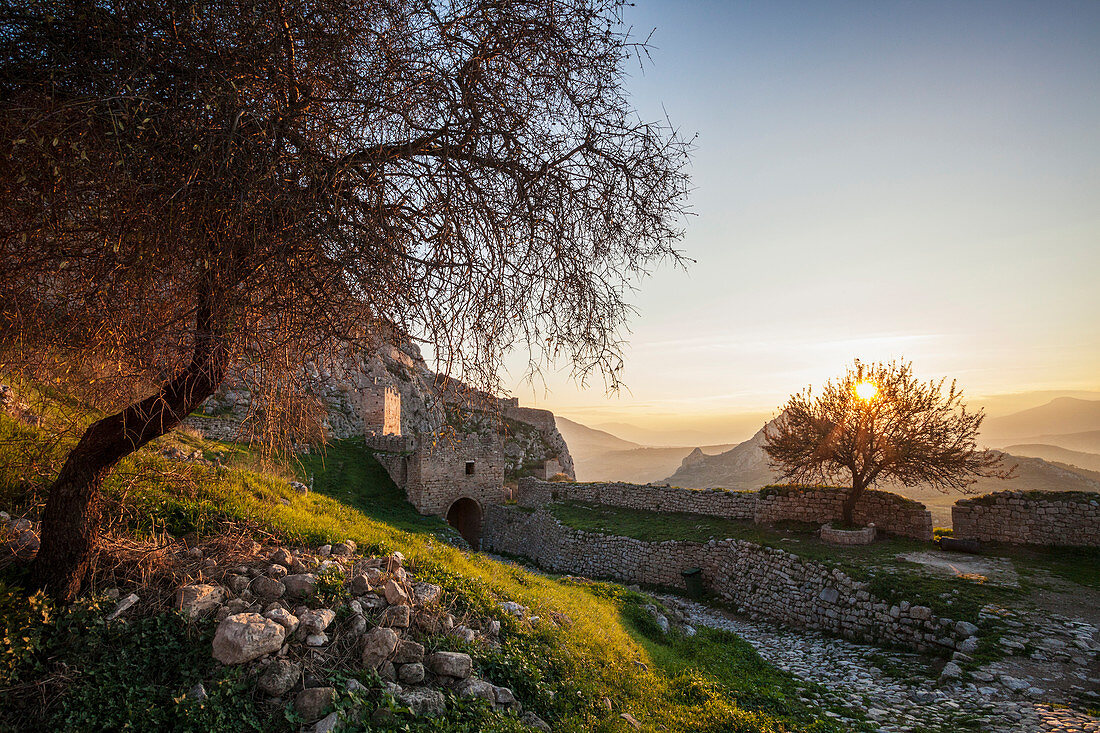 Ruins of stone wall and building at sunset, Corinth, Greece