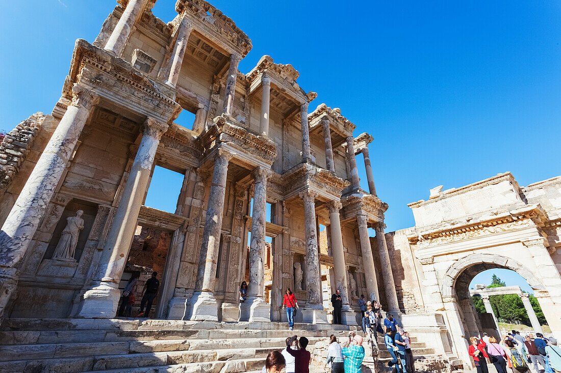Tourists at the ruins of the Celsus Library, a monumental tomb for Gaius Julius Celsus Polemaeanus, Ephesus, Izmir, Turkey