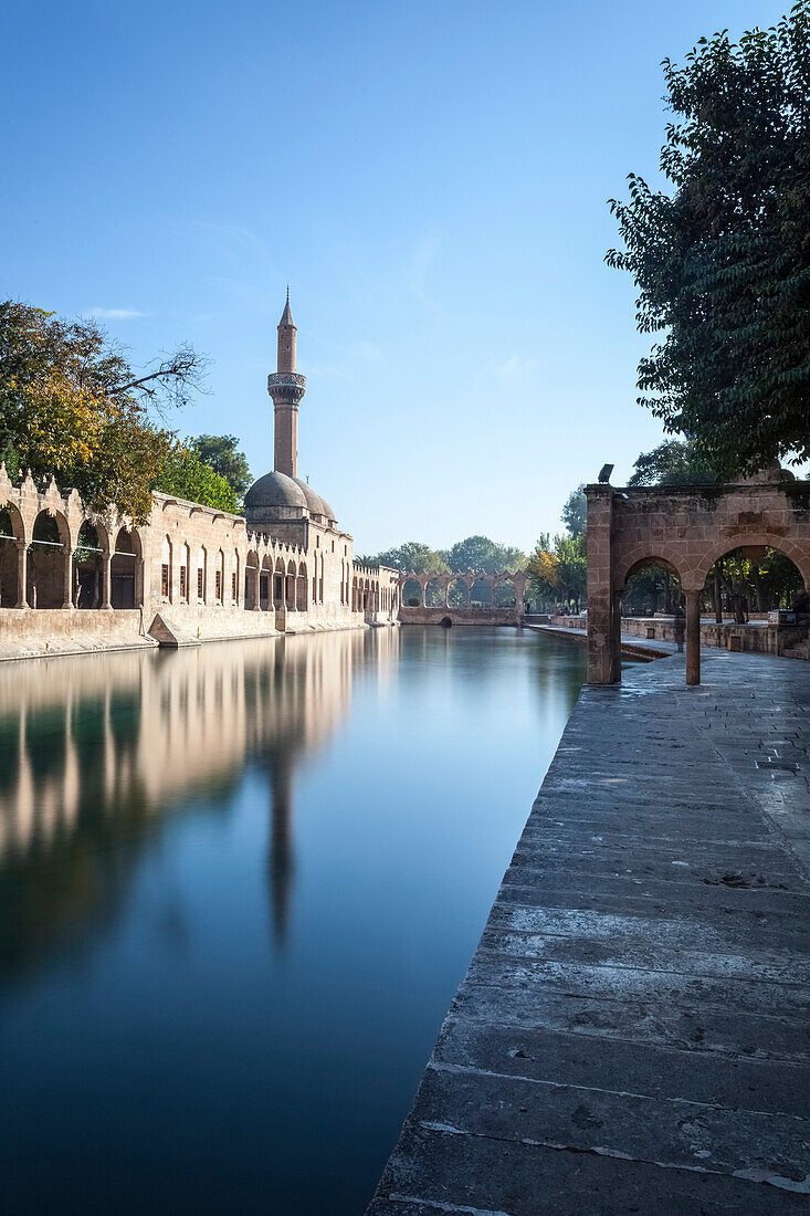 Chamber of Abraham, wall and minaret reflected in the tranquil water of a lake, Sanliurfa, Turkey