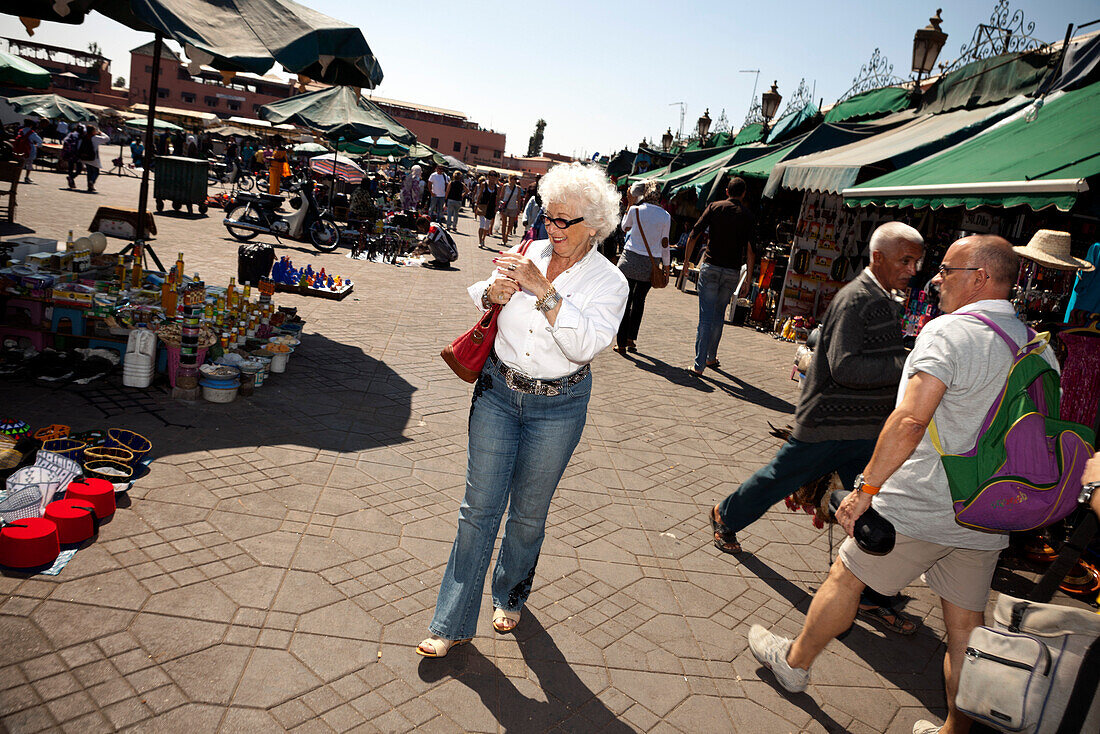 Woman walking in Jemaa el Fna market square, Marrakech, Morocco