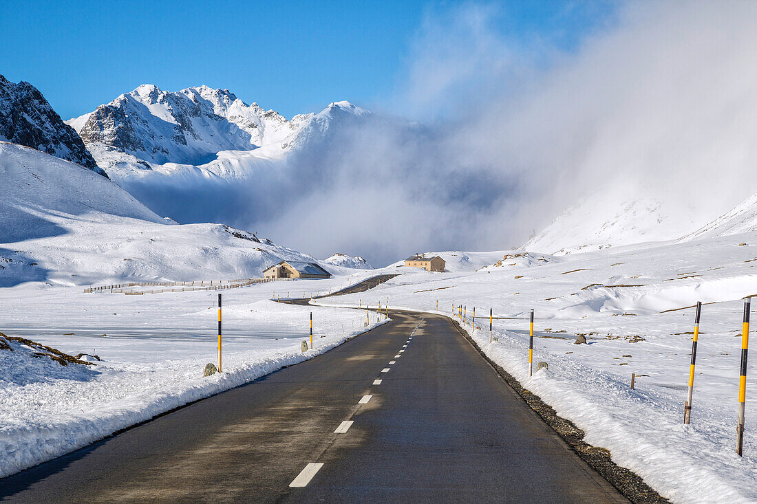 The road runs through the snow covered valley, Albula Pass, Engadine, Graubunden, Switzerland, Europe