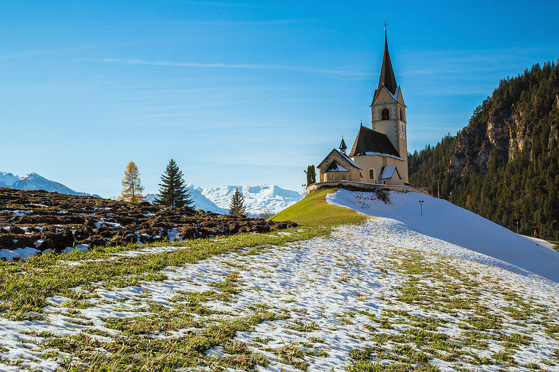 The church of the little village of Schmitten surrounded by snow, Albula District, Canton of Graubunden, Switzerland, Europe