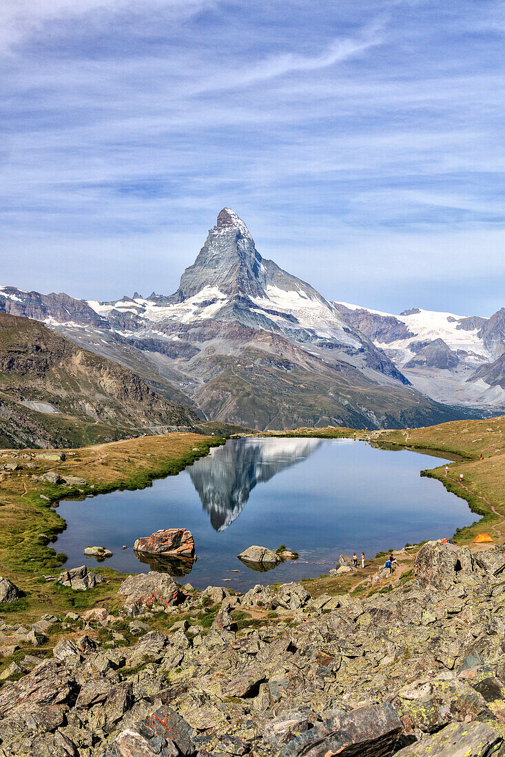 Hikers admire the Matterhorn reflected in Lake Stellisee, Zermatt, Canton of Valais, Pennine Alps, Swiss Alps, Switzerland, Europe