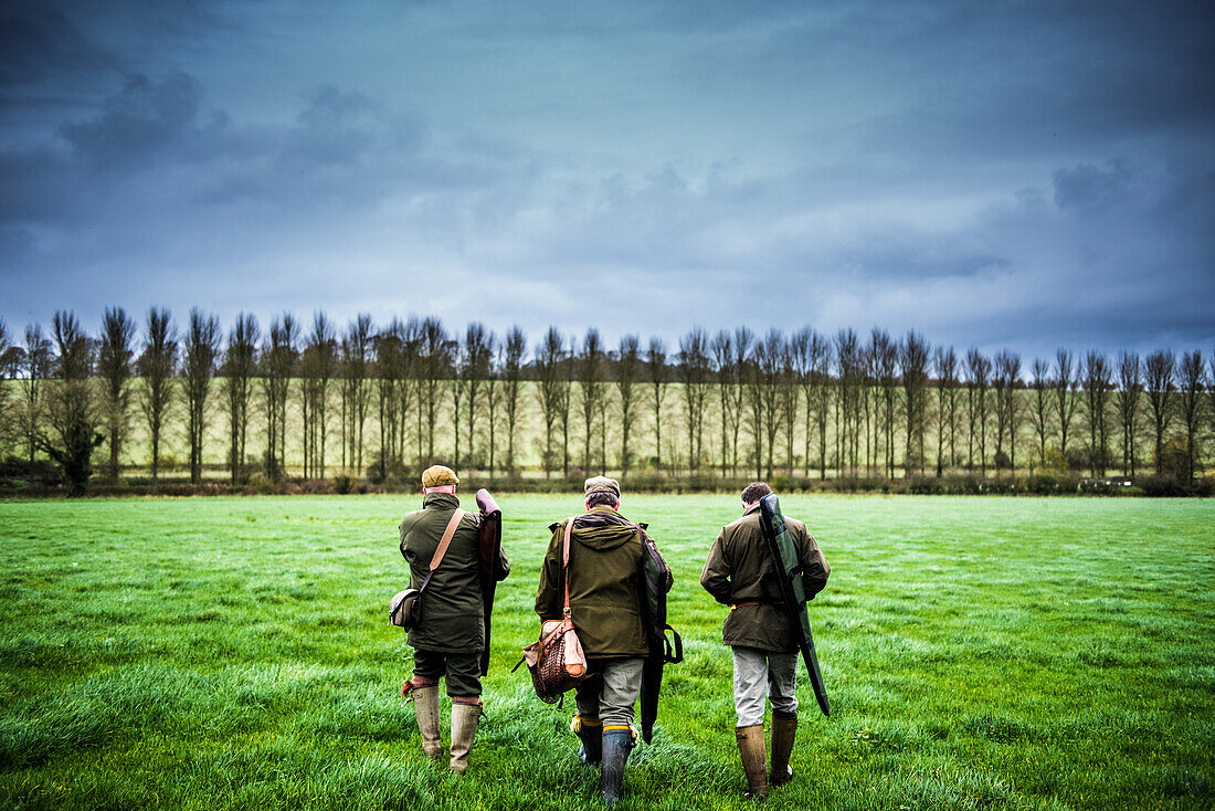 Three guns walking towards a drive, Wiltshire, England, United Kingdom, Europe