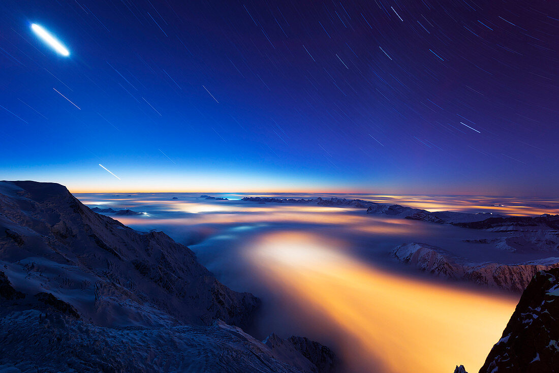 Sea of clouds weather inversion over Chamonix valley, star and moon light trails, Chamonix, Rhone Alpes, Haute Savoie, France, Europe
