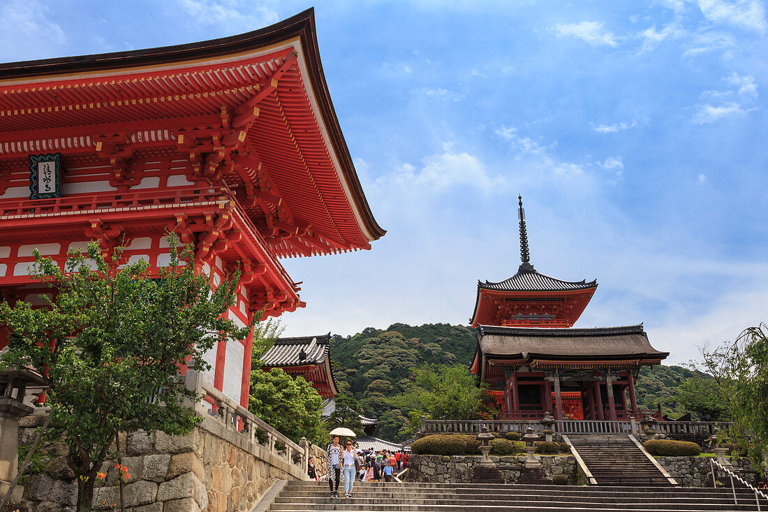 Visitors with sun umbrella in summer, vermillion temple entrance buildings, Kiyomizu-dera, Southern Higashiyama, Kyoto, Japan, Asia