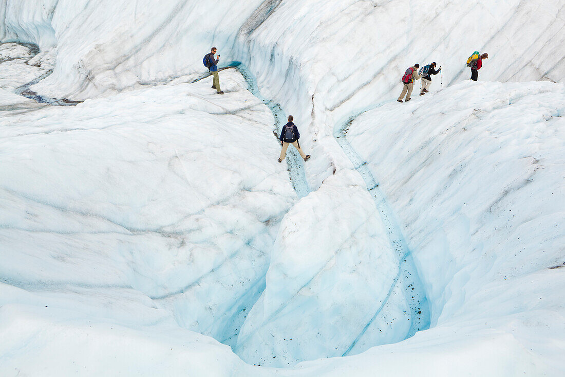 Clients are led by guide Ben Wilcox up a meltwater canyon on a day trip on the Root Glacier in Wrangell-St. Elias National Park, Alaska.