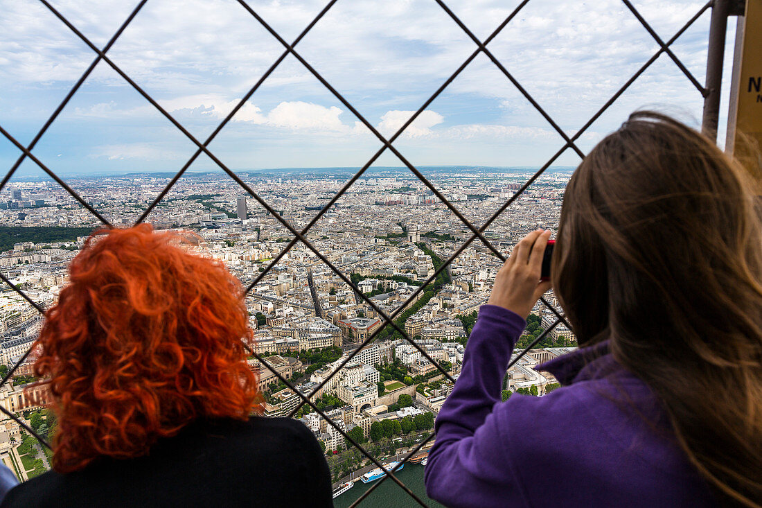 women enjoying the view from Eiffel Tower over the city of Paris, France, Europe