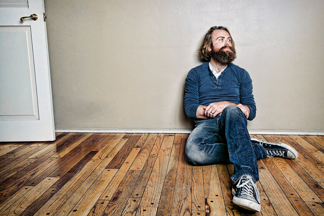 Caucasian man sitting on floor