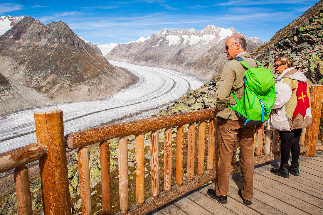 couple de randonneurs seniors admirant le panorama sur le glacier d'aletsch, site des alpes suisses classe au patrimoine mondial de l'unesco, bettmeralp, canton du valais, suisse