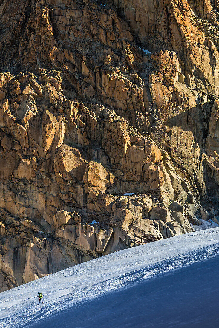 mountain climber in front of a rocky mountainside, col du tour noir pass, argentiere, refuge d'argentiere, upper savoy, haute-savoie (74), rhone-alpes, france