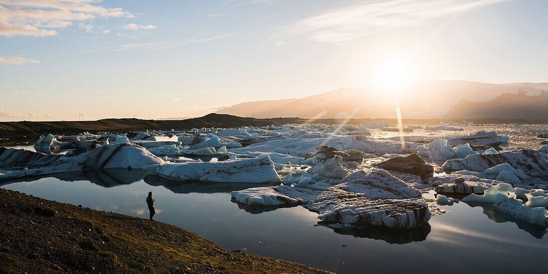 Tourist at Jokulsarlon Glacier Lagoon at sunset, South East Iceland, Iceland, Polar Regions