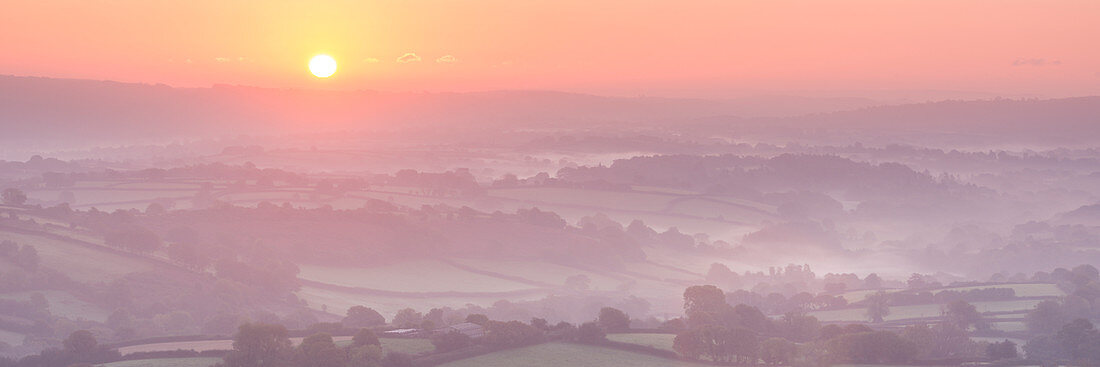 Sunrise over mist covered rolling countryside, Dartmoor, Devon, England, United Kingdom, Europe