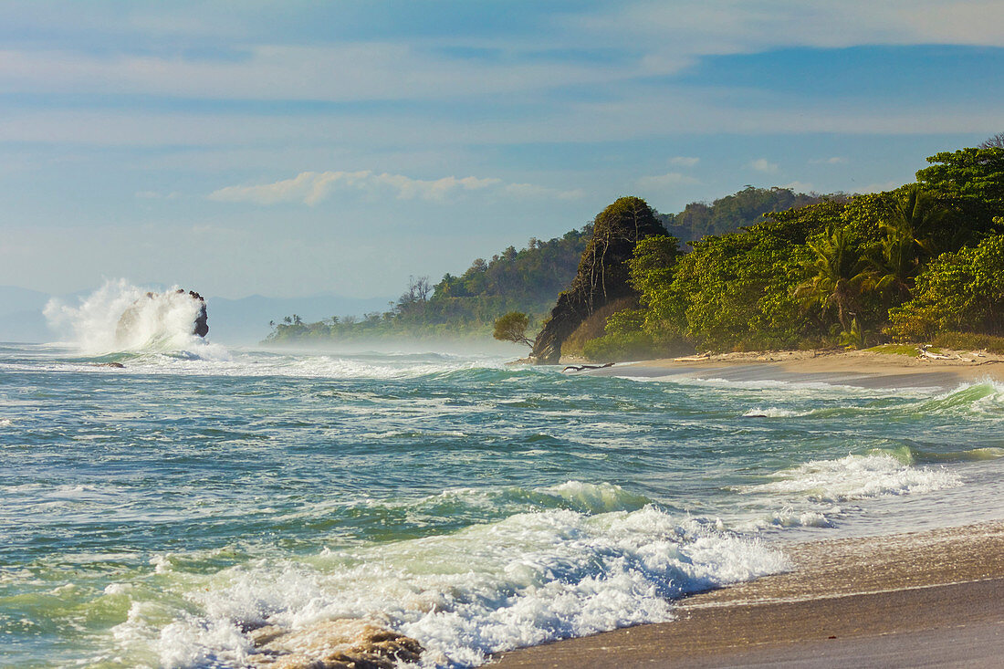 Surf breaking on sea stack and the Penon rock at this far south Nicoya Peninsula beach, Santa Teresa, Puntarenas, Costa Rica, Central America