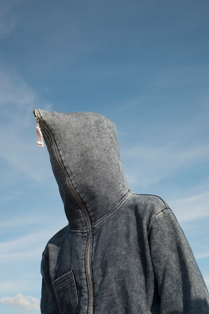 Low angle view of person covered with hood against sky